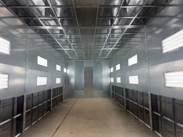 The lit white interior of an industrial spray booth