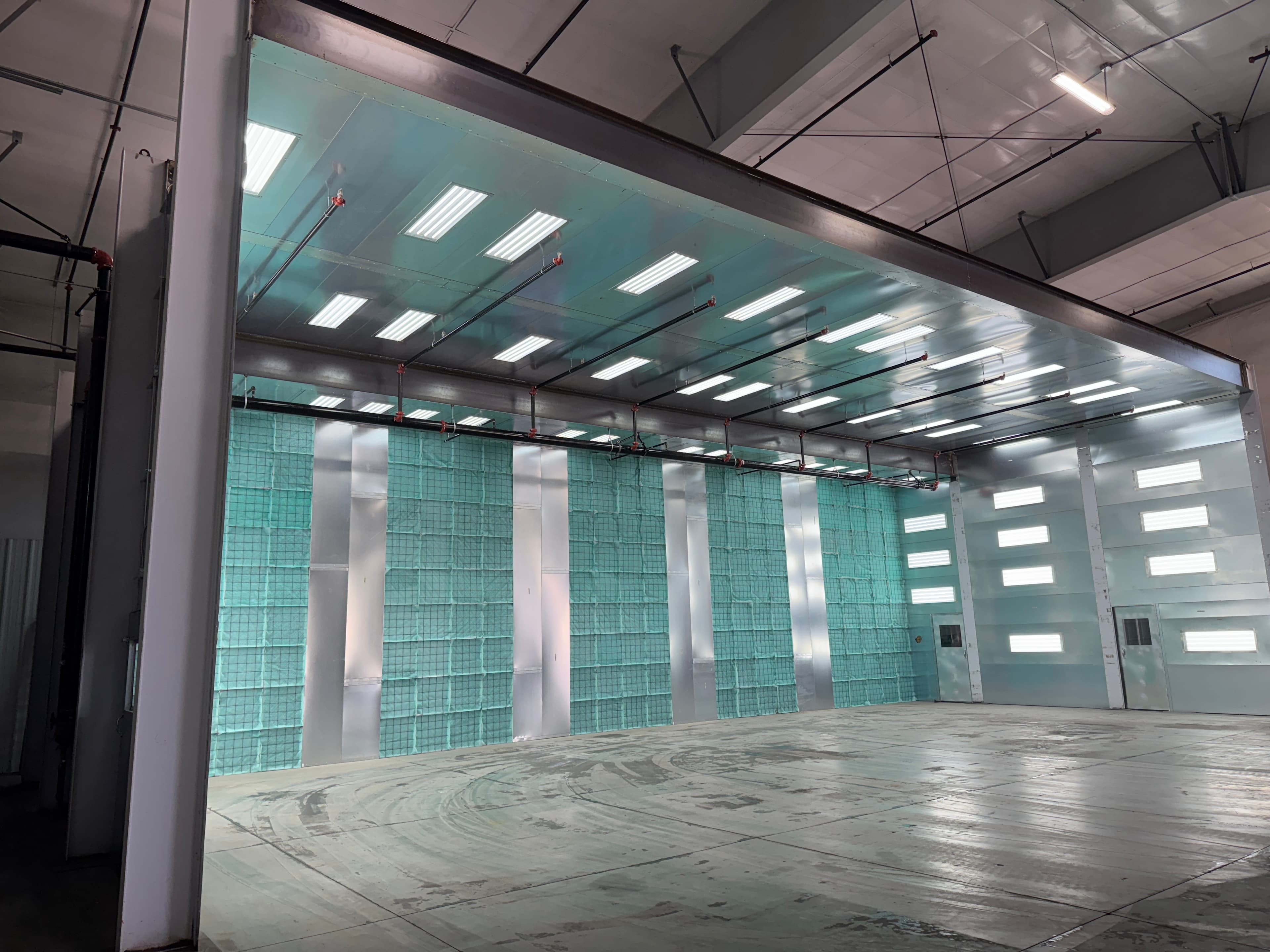A wide industrial spray booth installed in a plant