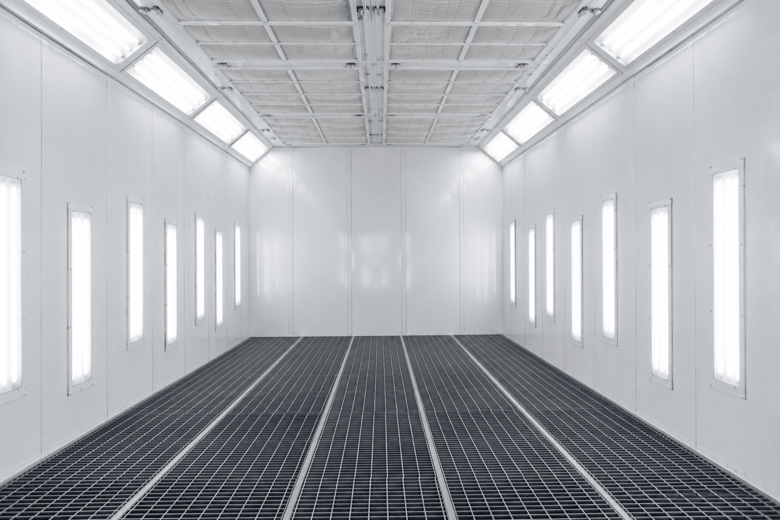 Interior of an industrial downdraft spray booth with grated floor and full ceiling plenum lighting